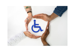 Four hands of people with different skin tones forming a circle around the universal blue wheelchair accessibility icon.